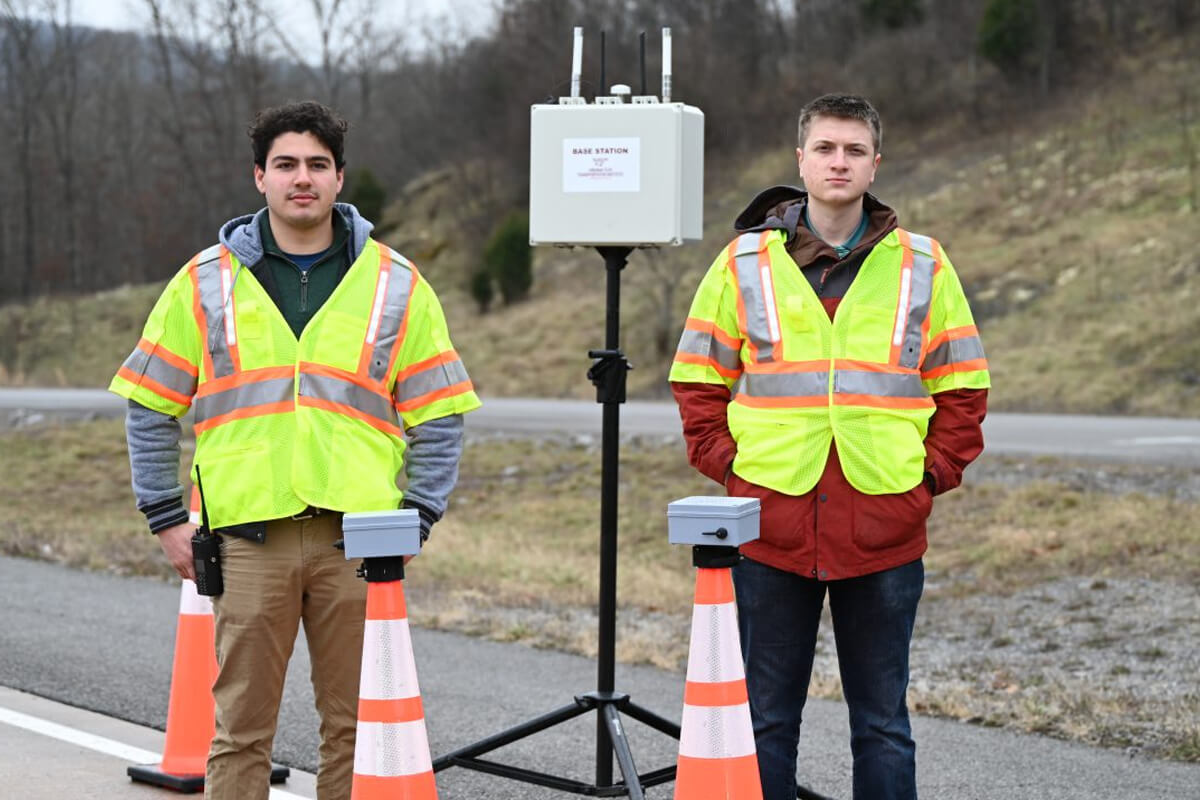 Student researcher Daniel Burdisso (at left) and Research Associate Will Vaughan stand with the VTTI smart work zone system. Photo by Jean Paul Talledo Vilela for Virginia Tech.