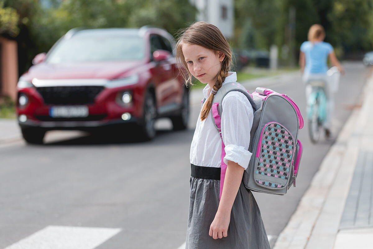 A child looking to cross the street